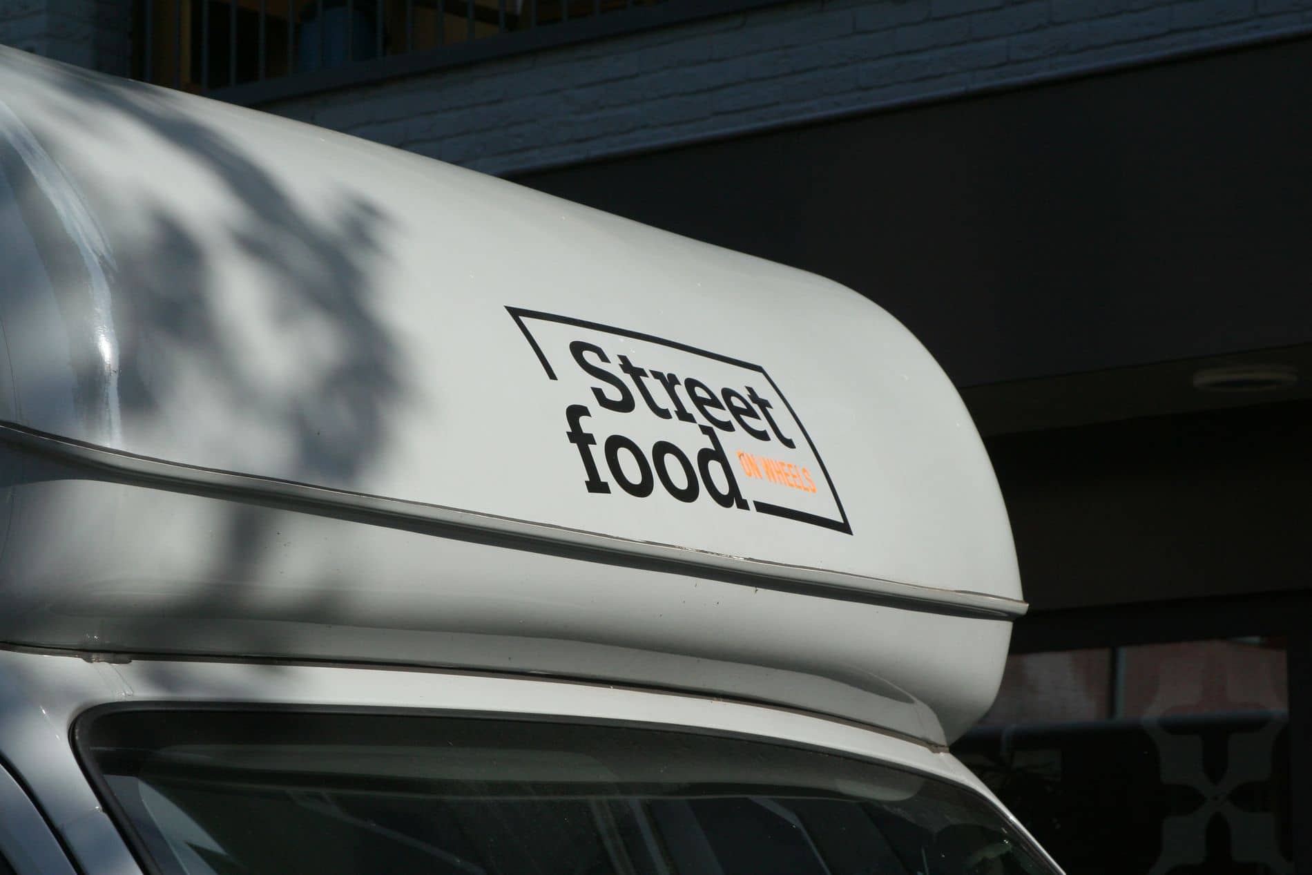 Het logo op de cabine van de zilveren foodtruck