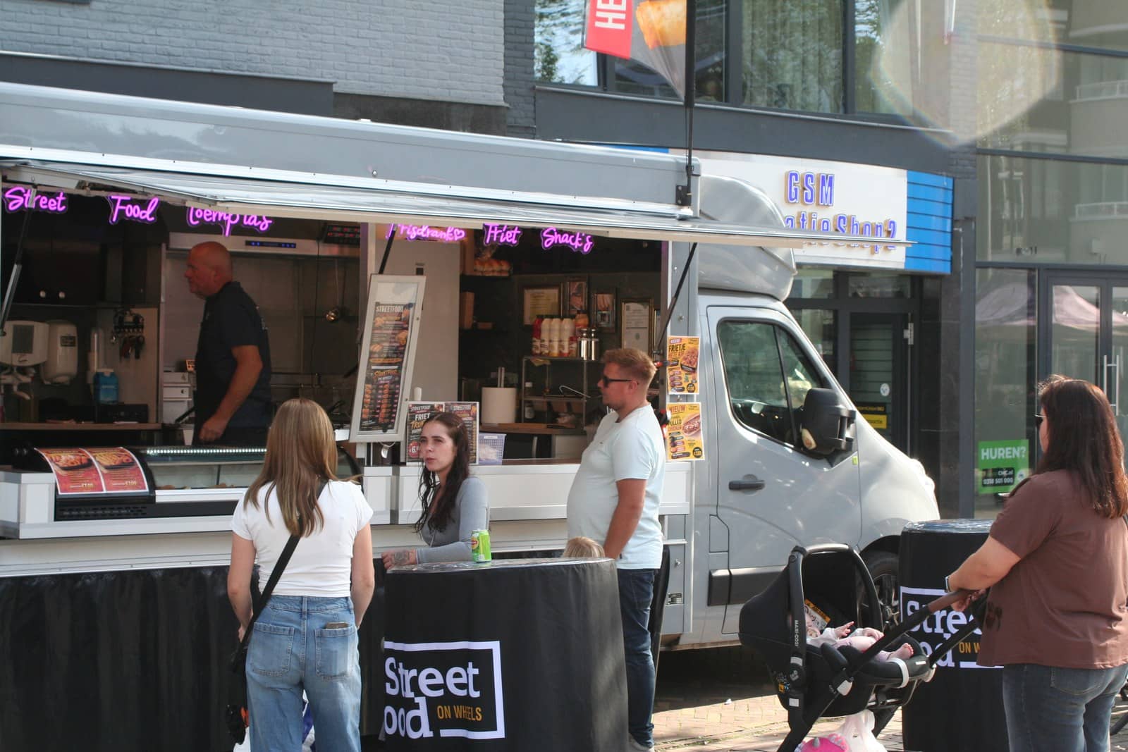 Klanten bij de foodtruck op een zonnige marktdag