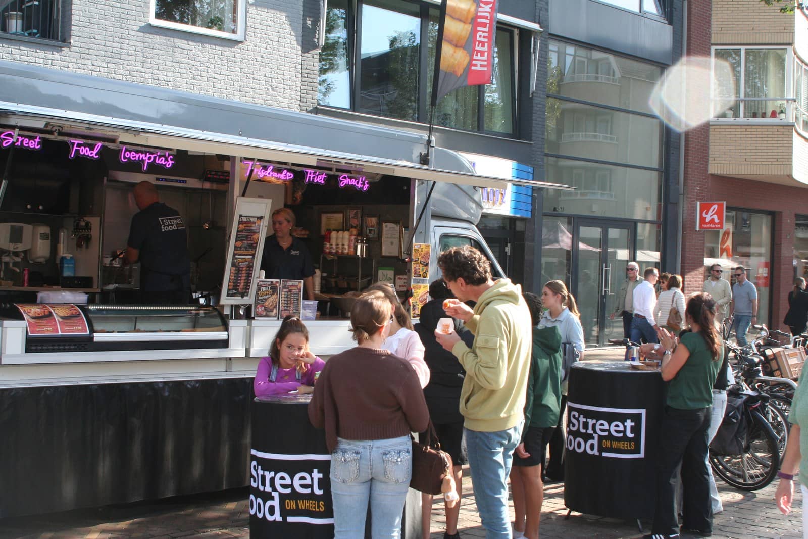 Klanten aan de statafels voor de foodtruck