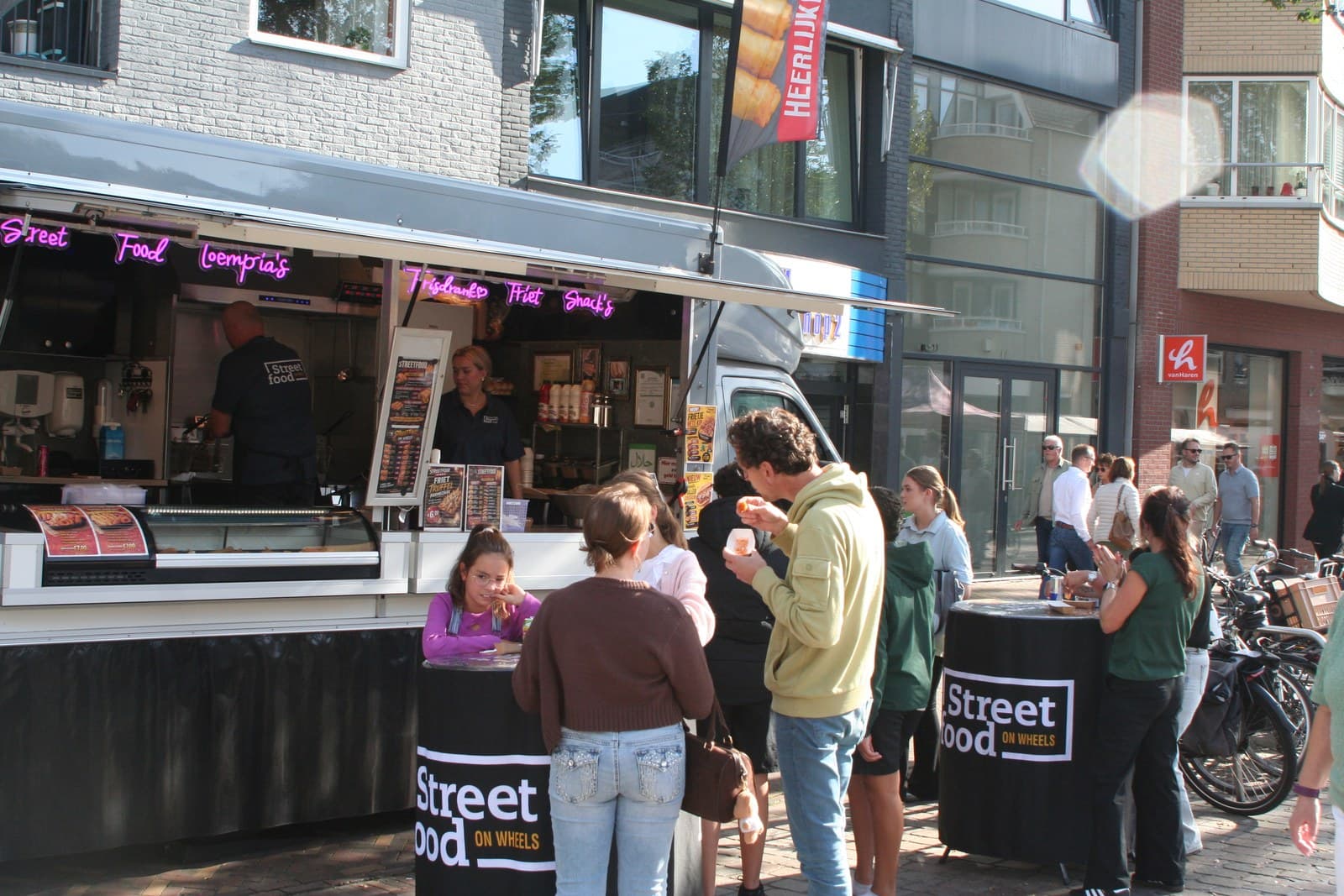 Klanten aan de statafels voor de foodtruck